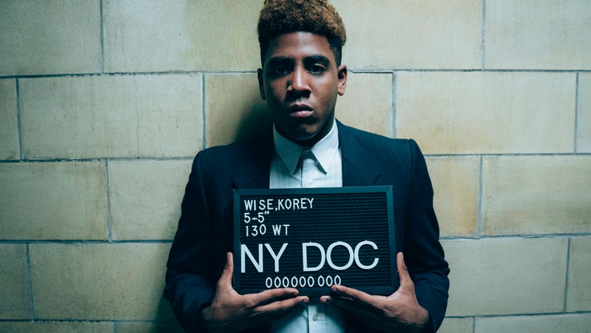 Fotograma en el que aparece Jharrel Jerome haciendo de Korey Wise con una placa de identificación en comisaría