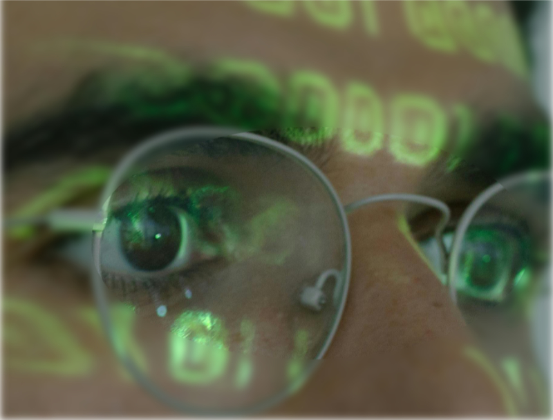 Código binario reflejado en gafas y frente